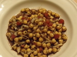 Kichererbsensalat im Teller mit Tomate und Zwiebel